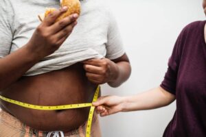 overweight male measuring waist